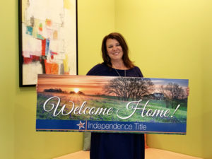 Lori Allmer holding Welcome Home sign